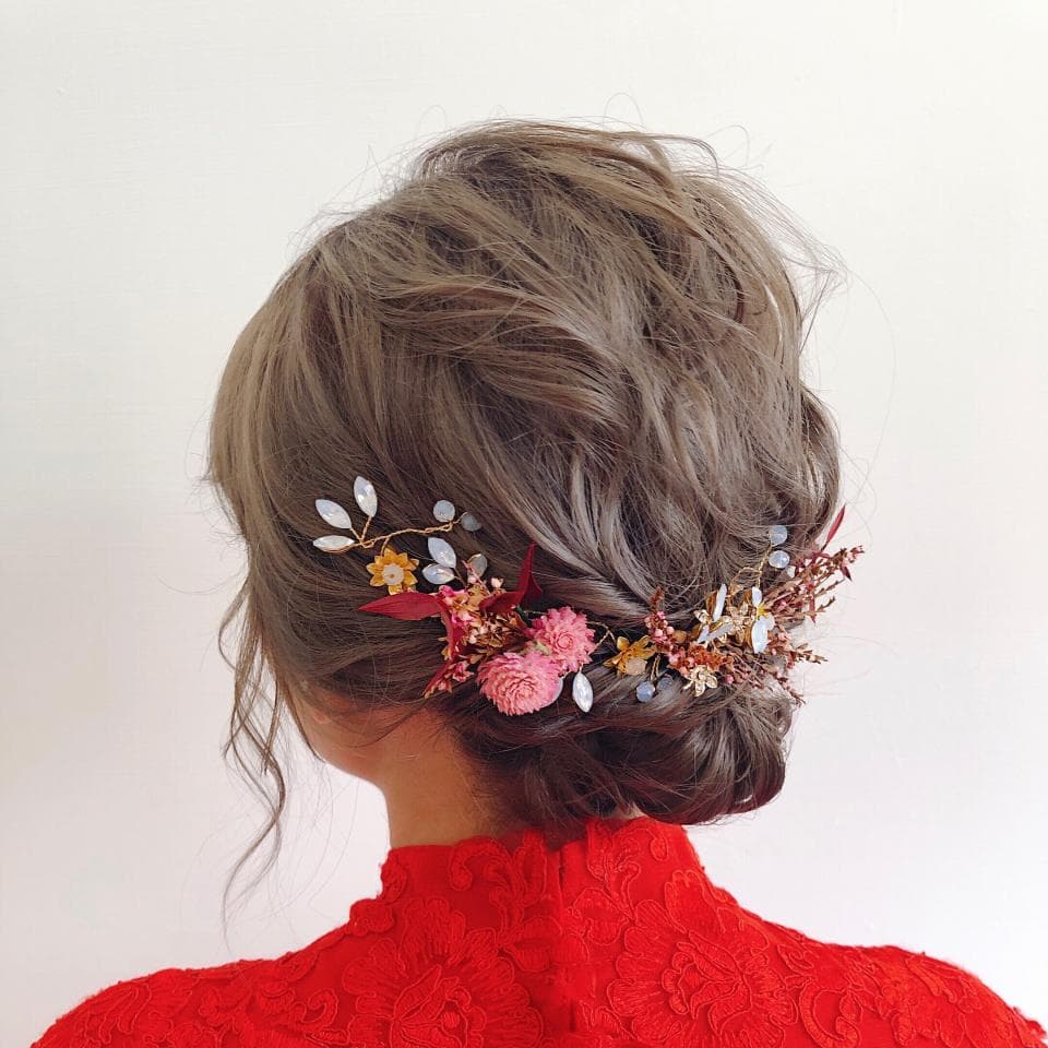 這張「新娘」的照片是一個穿著紅色洋裝的女人,她的頭髮上插著花朵和珠寶髮飾。