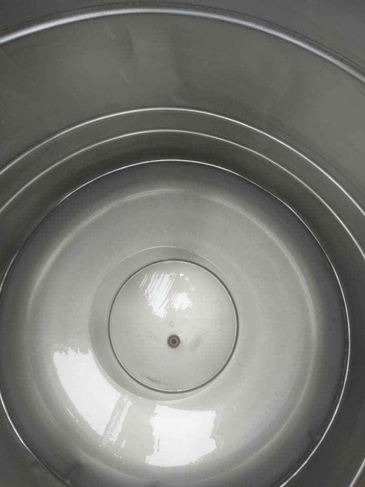 1) 照片顯示一個不銹鋼桶的內部,桶壁光滑,底部有一個圓形開口
