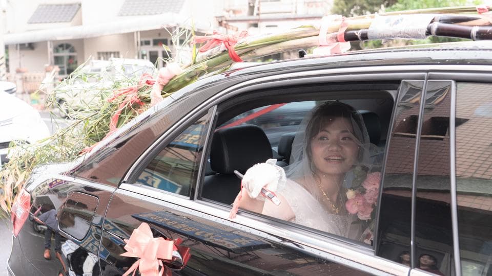 這張「婚禮」的照片是一對新人坐在黑色轎車裡,新娘穿著白色婚紗,露出幸福的笑容。