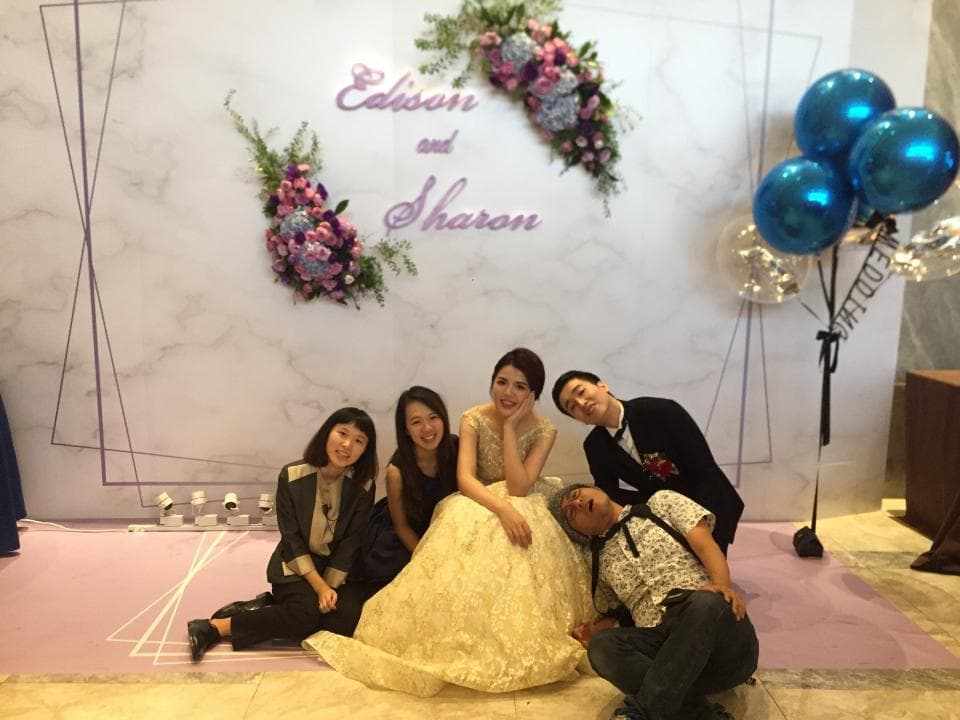 這張照片是一對新人婚禮的合照,新郎新娘站在中間,其他親朋好友在旁邊。