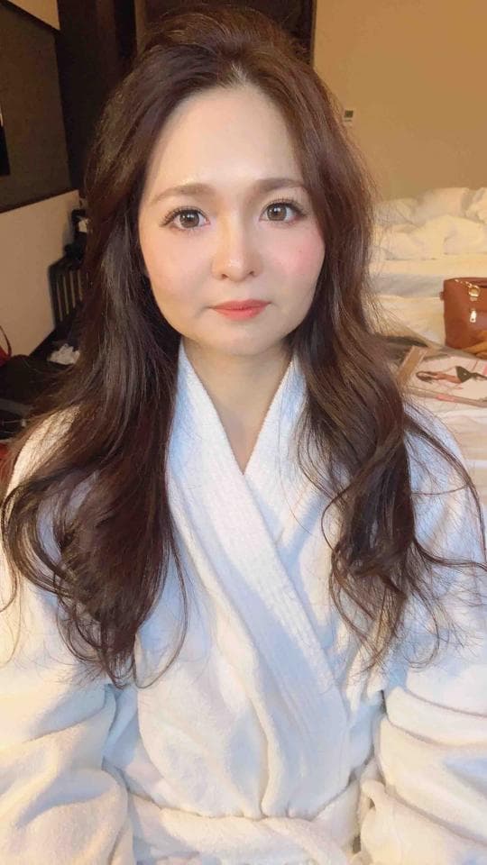 這張照片是一位穿著白色浴袍的女性。