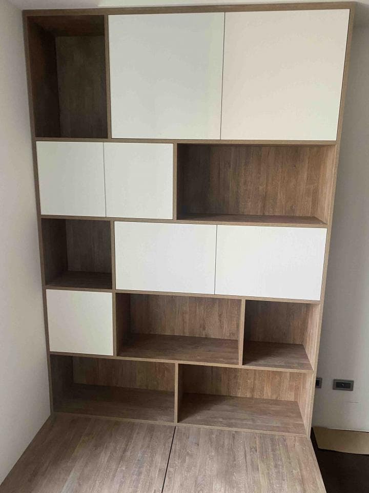 這張照片是一個現代化的書架,它由木頭和白色板子製成,擁有許多層架,可以放很多書和物品。