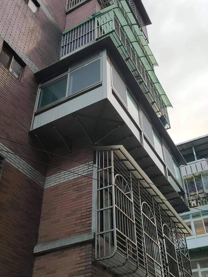 1) 照片顯示一棟紅磚建築物,陽台有鐵窗