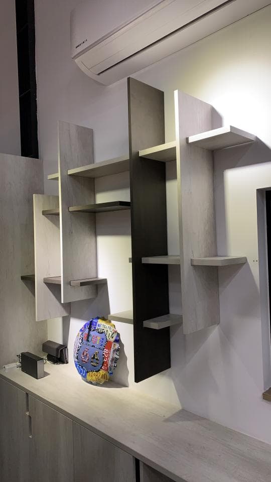 這張照片是一個現代化的房間,牆壁上安裝了一個由木板組成的架子,架子上放著一個藍色和紅色的裝飾品。