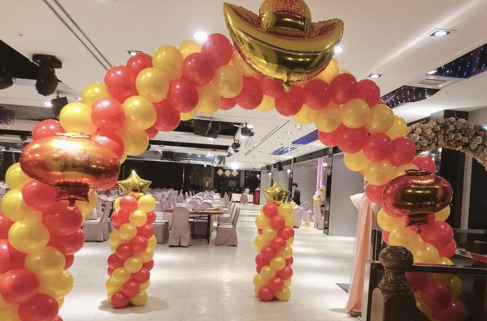 這張「婚禮」的照片是一個以紅色和黃色氣球裝飾的拱門。