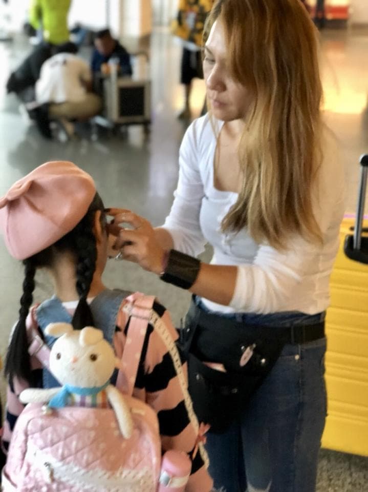 這張照片是一對母女在機場,媽媽正在幫女兒整理頭髮。