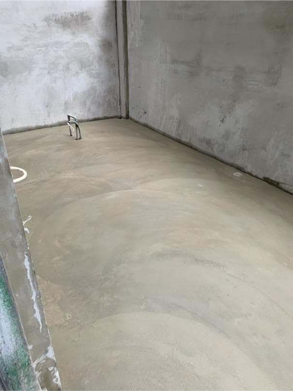 這張照片是一間剛裝修好的房間,房間裡的地板是水泥做的,非常光滑平整,看起來很新。