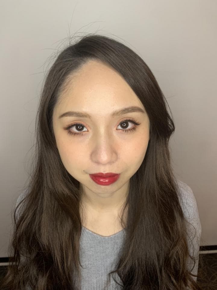 這張「一位年輕女性」的照片是,她留著長長的黑色頭髮,穿著灰色的上衣,看起來很溫柔。