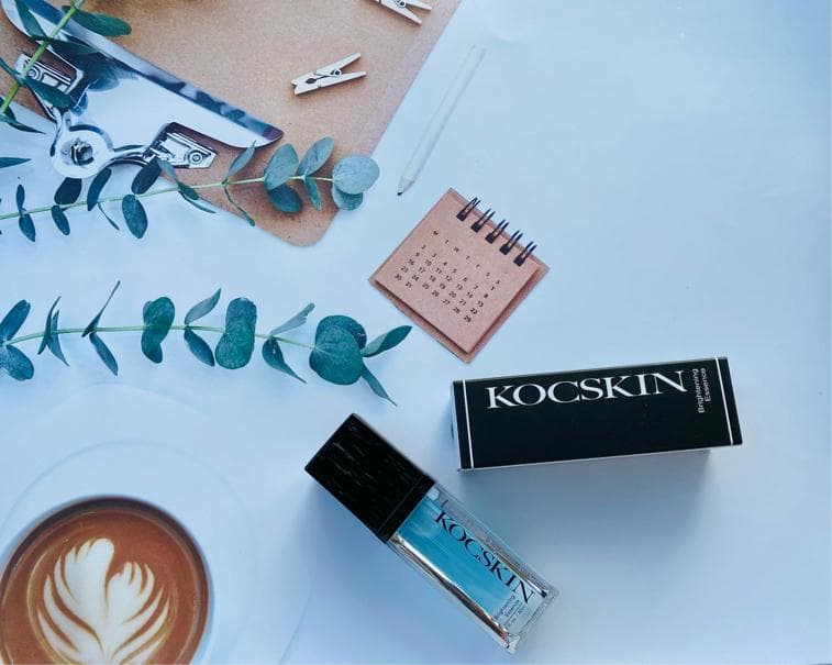 這張照片是兩瓶不同的護膚產品,一瓶是黑色盒子,上面寫著“KOCSKIN”;另一瓶是透明玻璃瓶,裡面是藍色液體,瓶身上也寫著“KOCSKIN”。
