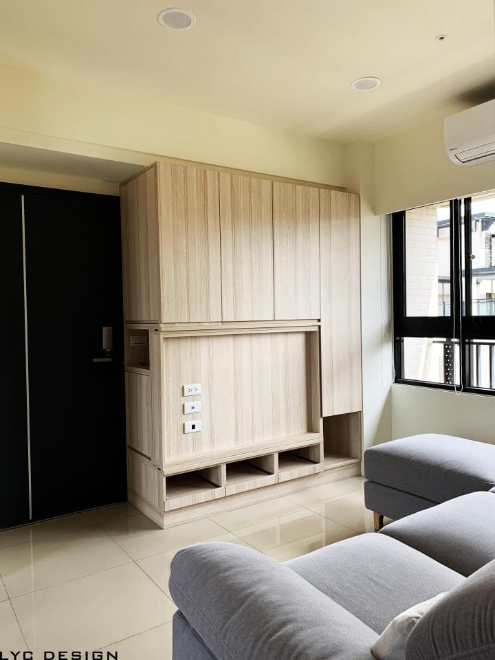 這張照片是一個現代化的客廳,最重要的是牆上的一組木質櫥櫃,它結合了開放式和封閉式的設計,提供了儲物空間和展示空間。