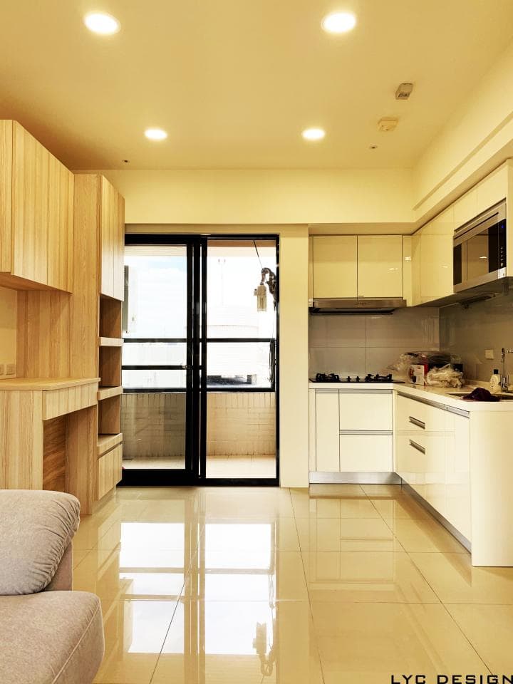 這張照片是客廳與廚房的空間,照片中最重要的部分是客廳與廚房的地板,地板是淺色磁磚,光線照射下非常明亮。