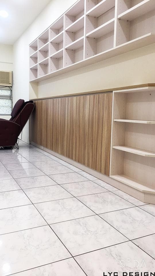 這張照片是房間的一角,最重要的是牆上的一排書架,由白色的木板製成,有許多格層,可以擺放很多東西。書架的下方是木紋的櫃子,看起來很美觀實用。