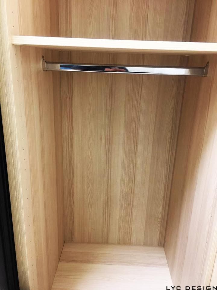 這張照片是一個木質衣櫃的內部,最重要的是衣櫃內部的衣架,它是由金屬製成,安裝在木質隔板上,看起來很堅固。