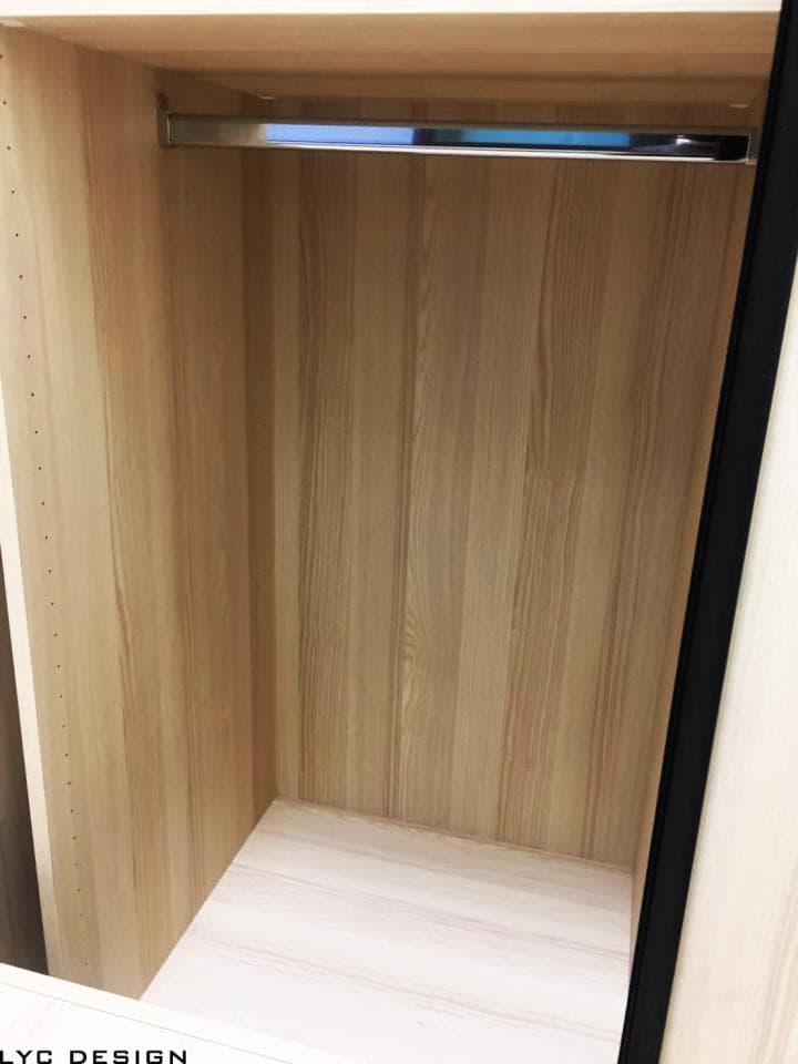 這張照片是一個木質衣櫥的內部,最重要的是衣櫥上方的水平衣架,它是由金屬製成,可以掛衣服。