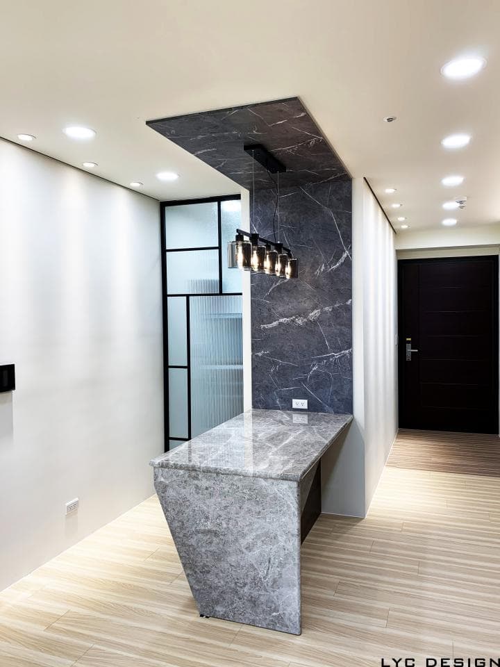 這張照片是現代風格的室內設計,最重要的是牆壁上獨特的石材紋理和懸吊式燈飾,營造出簡約而奢華的氛圍。