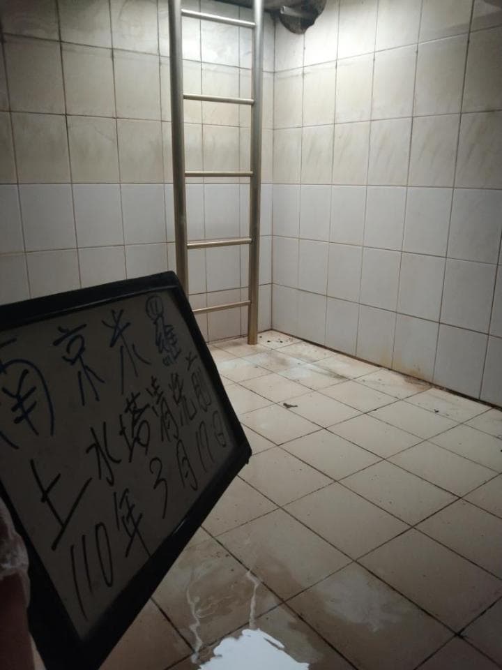 這張照片是一個寫著「10年3月舊牆翻新完畢」的白色板子。