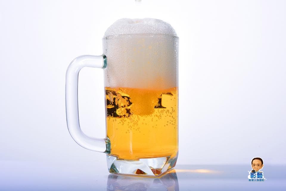 這張照片是一杯裝滿啤酒的玻璃杯,杯子裡有豐富的泡沫,啤酒的顏色是金黃色的,看起來很誘人。