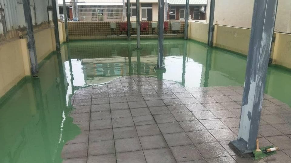 1) 這是一張房屋屋頂的照片,屋頂上有綠色的防水塗料,並且還有一部分是灰色瓷磚