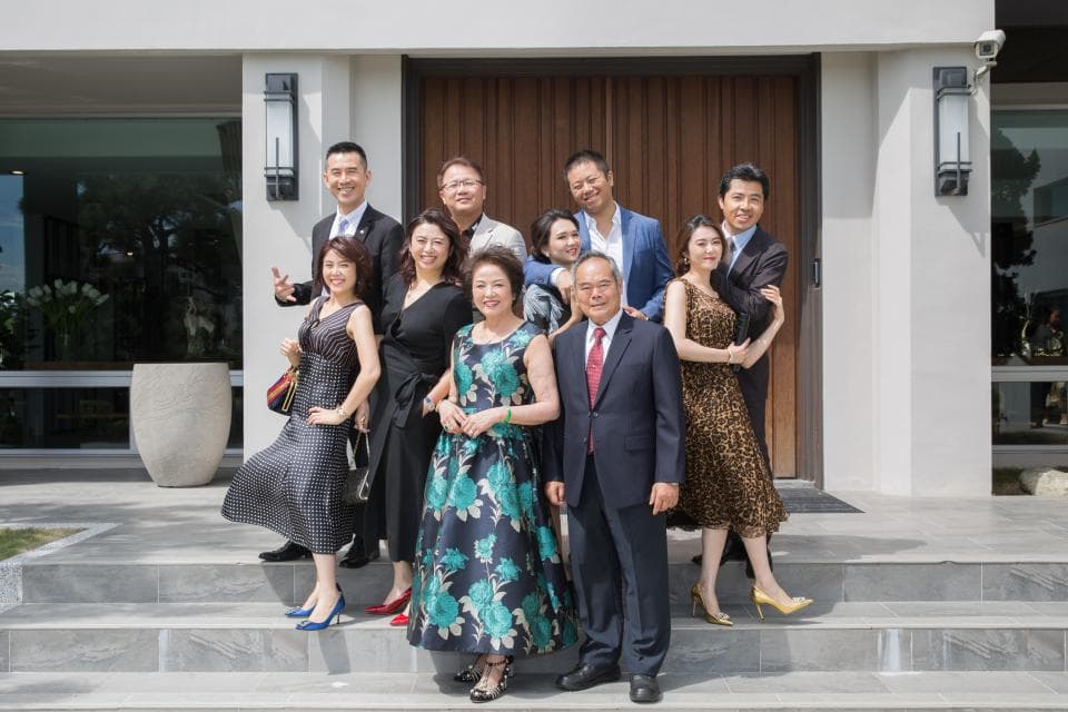 這張照片是一個家庭在戶外的大樓前合影留念。他們都穿著得體的衣服,臉上洋溢著幸福的笑容。最重要的是,他們一家和樂融融,展現出家人之間的愛和溫暖。