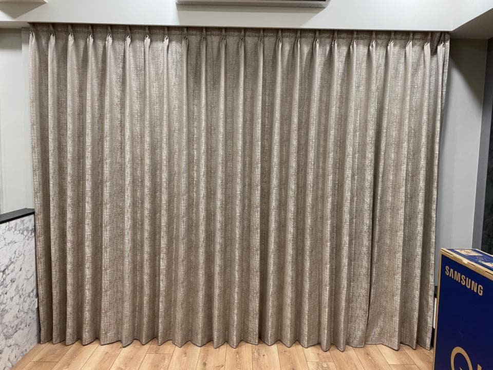 1) 照片顯示一間房間裡掛著的米色窗簾
