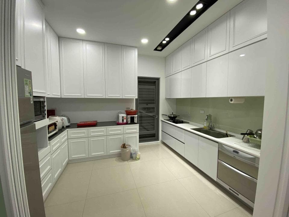 這張照片是一個現代化的廚房,最重要的部分是白色櫥櫃和檯面,它們營造出簡潔明亮的空間感。 橱柜和檯面上的精美線條和細節,使整個廚房看起來更加優雅和高級。