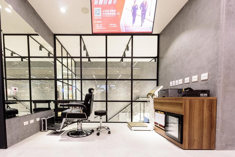 這張「理髮店」的照片是一個現代化的理髮店,其中包含一個皮革座椅,一個木質櫃檯和一個大型的鏡子。