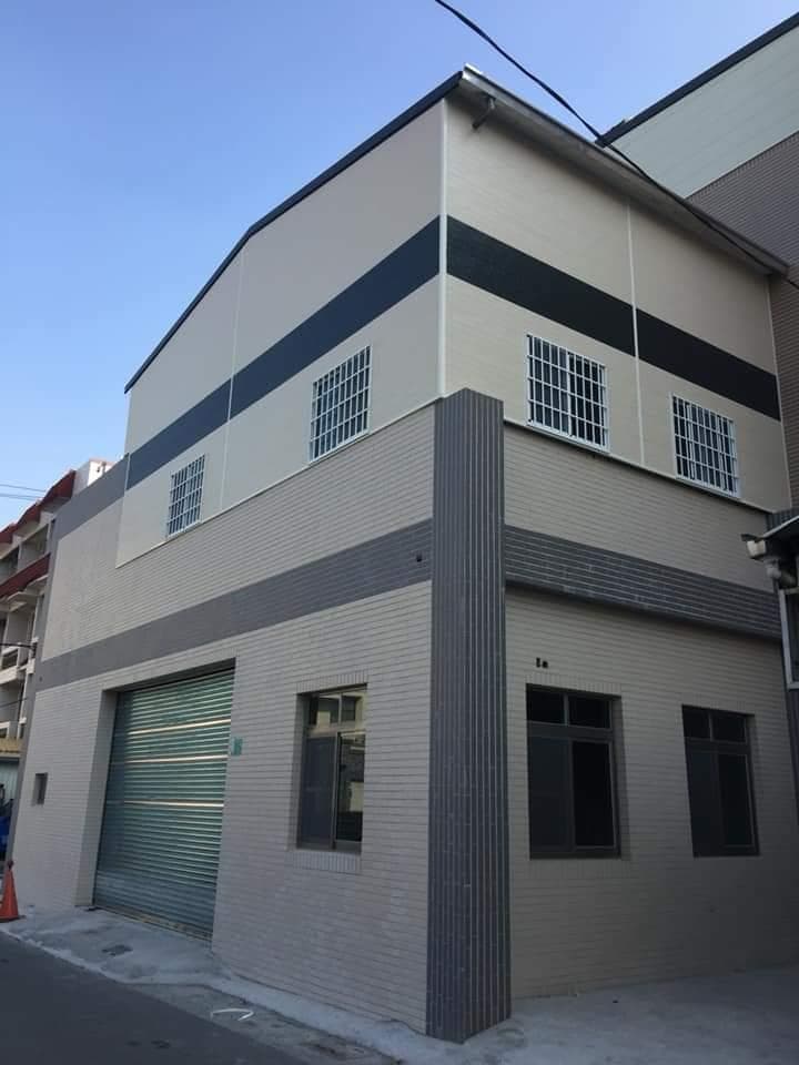 1) 照片中是一棟灰白色建築,建築物上有三扇窗戶以及一扇金屬捲門