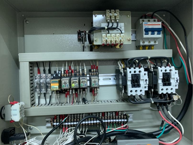 1) 照片顯示一個電氣控制箱,裡面有各種電氣元件,例如開關、繼電器和電線