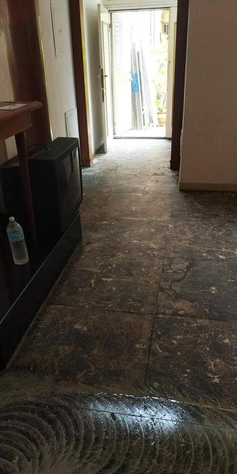 1) 照片顯示一間公寓或房屋的走廊,走廊的盡頭有一個門通往外面