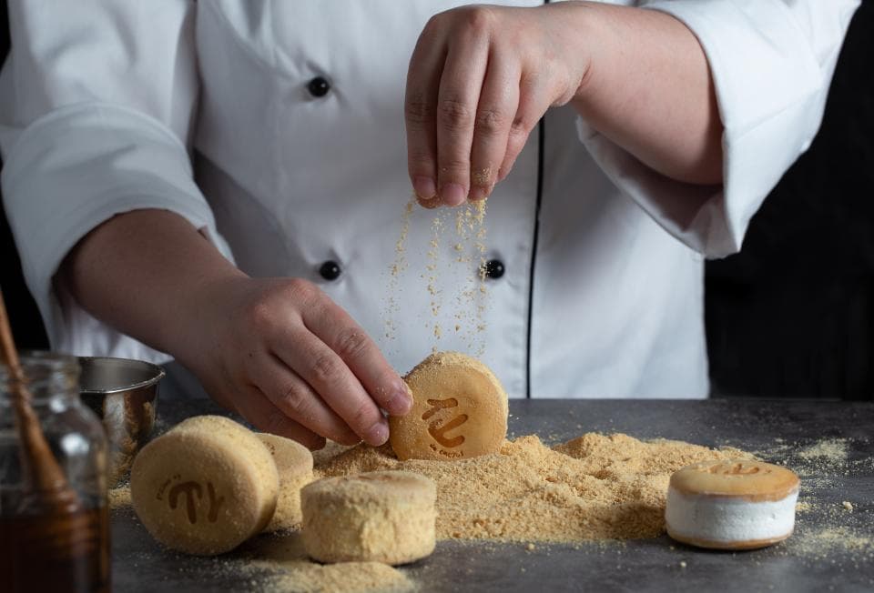 這張「糕點」的照片是一位廚師正在撒粉末在糕點上。