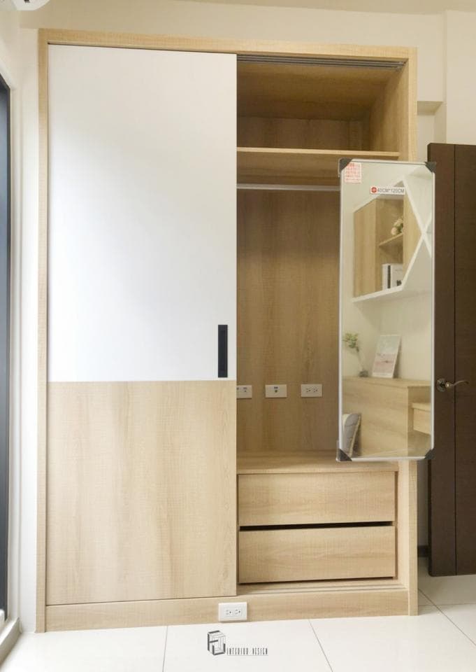 這張照片是一個現代化的衣櫃,有著白色和木頭色調的設計。衣櫃的設計簡潔,門板採用木紋裝飾,呈現出自然溫馨的風格。衣櫃內部則有一個鏡子,可以方便使用者整理儀容,整體設計實用美觀。
