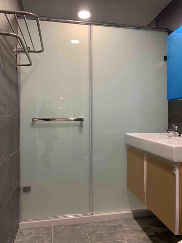 這張照片是一個現代化的浴室,其中最顯眼的是淋浴間,它採用了簡潔的設計,搭配透明的玻璃門和金屬把手,呈現出優雅的風格。