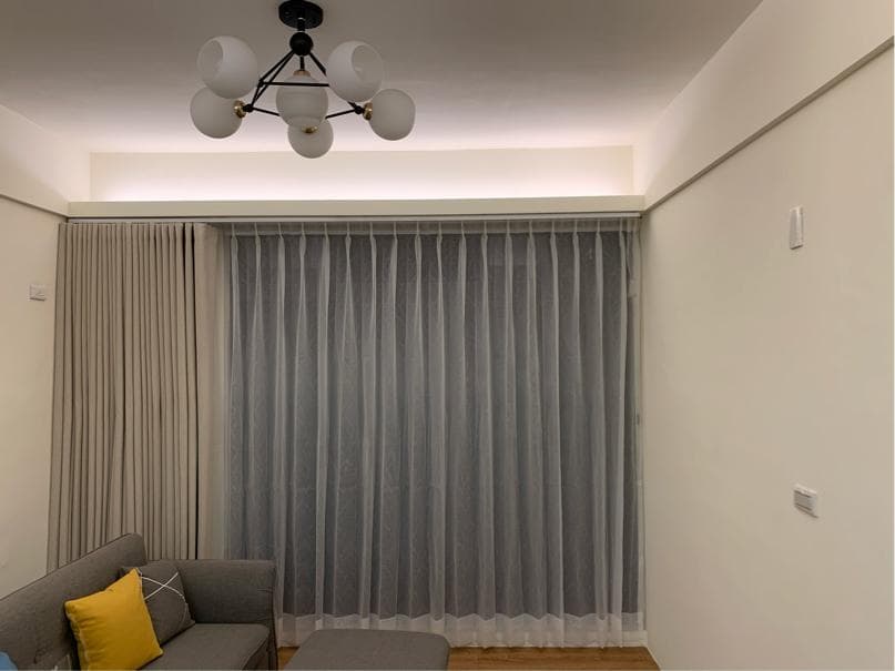 1) 照片顯示一間客廳,有兩層窗簾,窗簾是白色的,客廳牆壁是白色的,房間的燈是白色燈泡的燈具