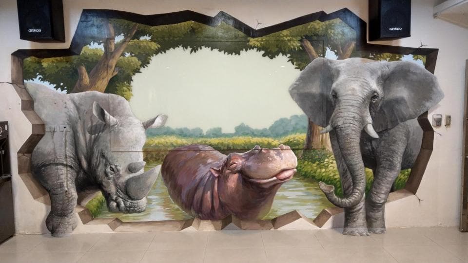 這張「3D 壁畫」的照片是三隻動物:河馬、犀牛和象,它們好像從牆壁中跳出來一樣。