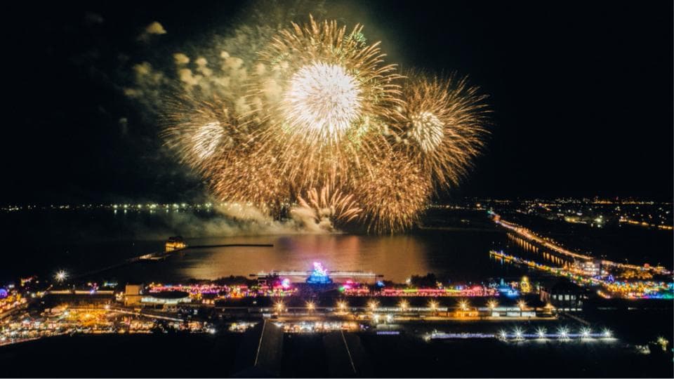 這張照片是一場在湖面上空燃放的煙火表演。煙火在夜空中綻放,照亮了湖面和周圍的建築物,形成了一幅美麗的夜空景象。