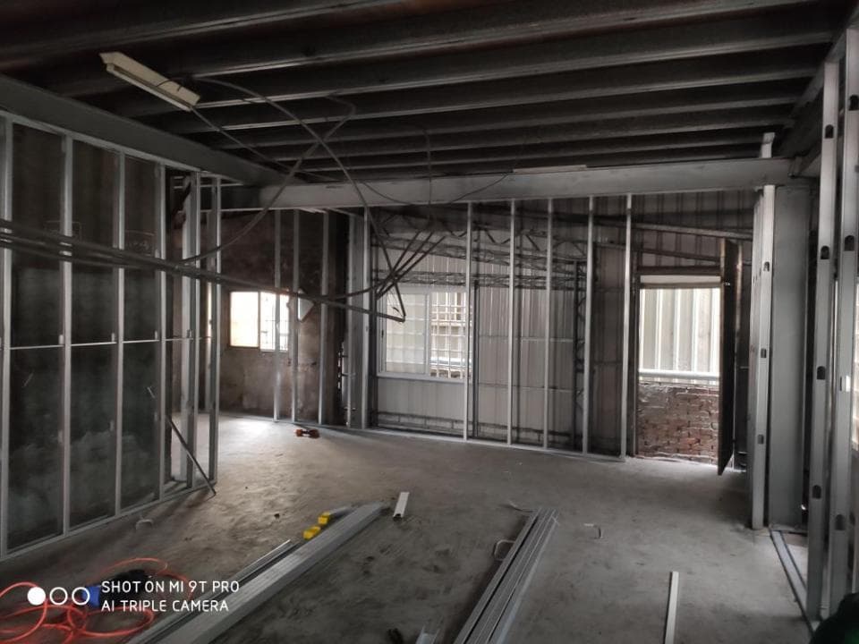 1) 照片顯示一個正在裝修中的房間,房間內部有許多金屬框架和線路