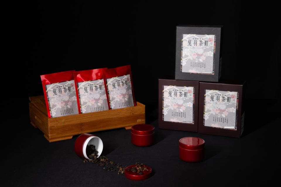 這張「茶葉」的照片是三包茶葉放在木盒裡,旁邊有三個茶罐,還有三個茶葉盒。