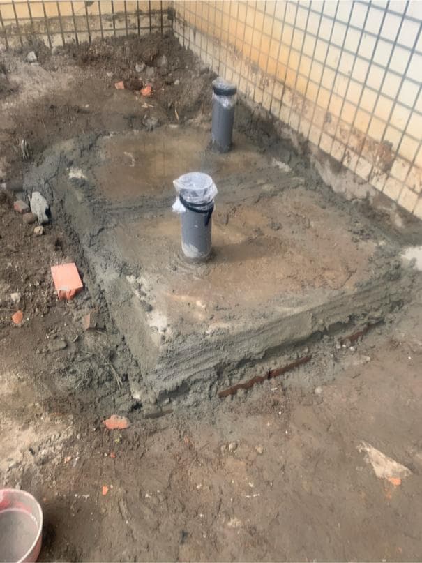 1. 照片顯示一個水泥平台,平台上有一個灰色的圓形蓋子,蓋子旁邊有一個灰色的圓柱體