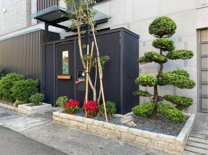 這張照片是現代住宅的入口,有種植一棵造型獨特的樹,樹的枝葉層層疊疊,被修剪成圓形,非常別緻。