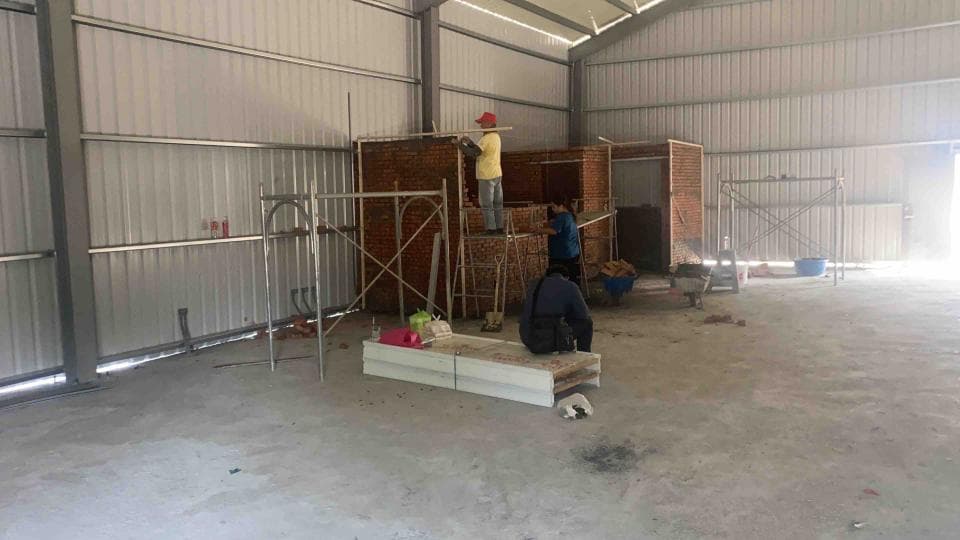 1) 照片顯示一個建築工地,裡面有三個工人正在工作