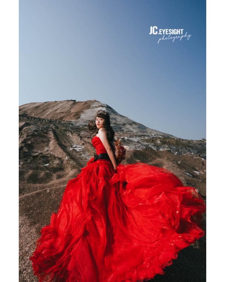 這張「婚紗照」的照片是一名女子穿著紅色蓬裙婚紗,在荒涼的環境下擺著姿勢。