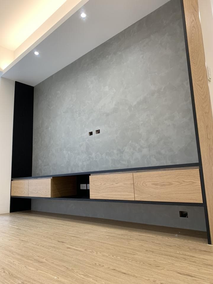 這張照片是一間客廳,最引人注目的地方是牆上的一組電視櫃,櫃子是由深色木板和淺色木板組合而成,整體風格簡潔現代。