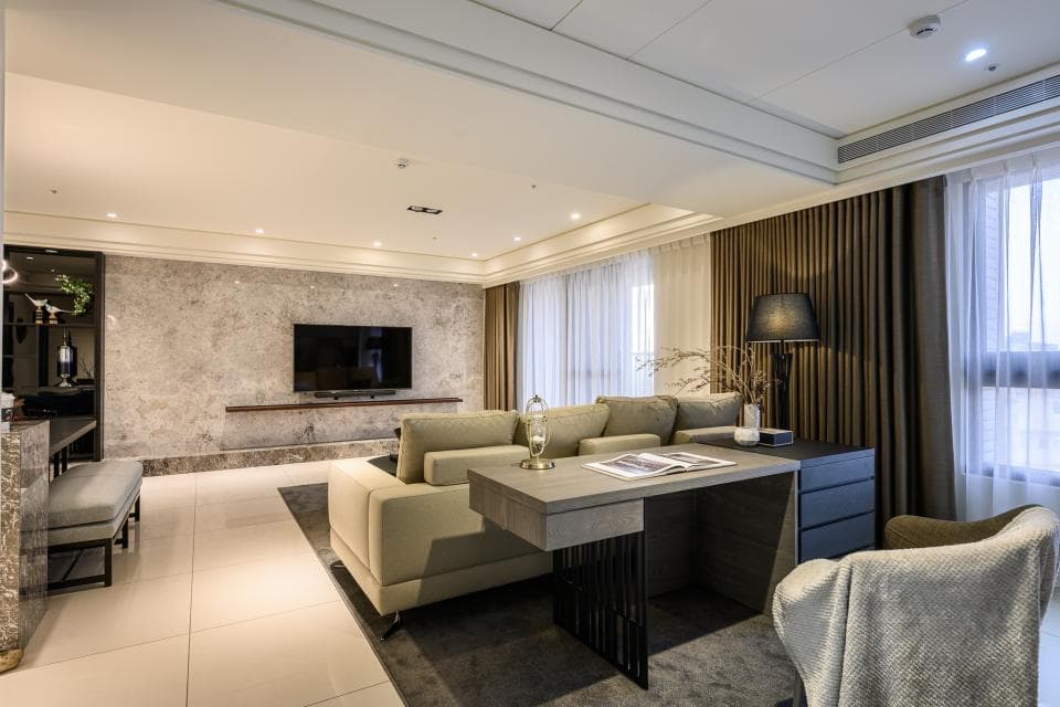 這張「客廳」的照片是一個寬敞明亮的現代化空間,有著舒適的沙發、大型電視、簡約的裝飾風格,以及一張木製的桌子。