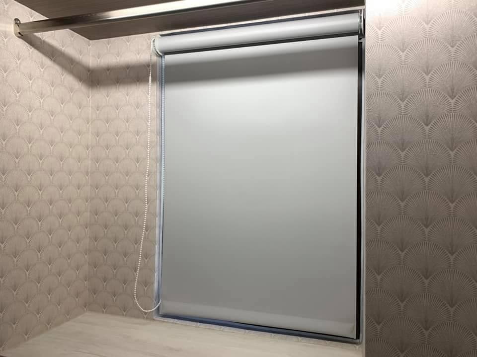 1) 牆上裝有淺灰色百葉窗簾,窗簾已拉下,窗簾下方有一個淺色木架