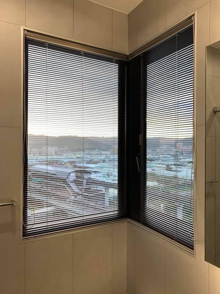 1) 這是一張浴室的照片,有一個角落窗戶,窗戶裝有百葉窗,從窗外可以看到城市景觀