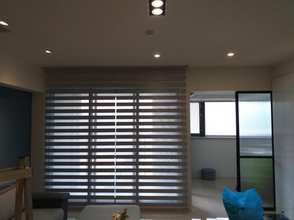 1) 照片顯示一個客廳,房間裡有灰色的百葉窗,以及一扇黑色的玻璃門