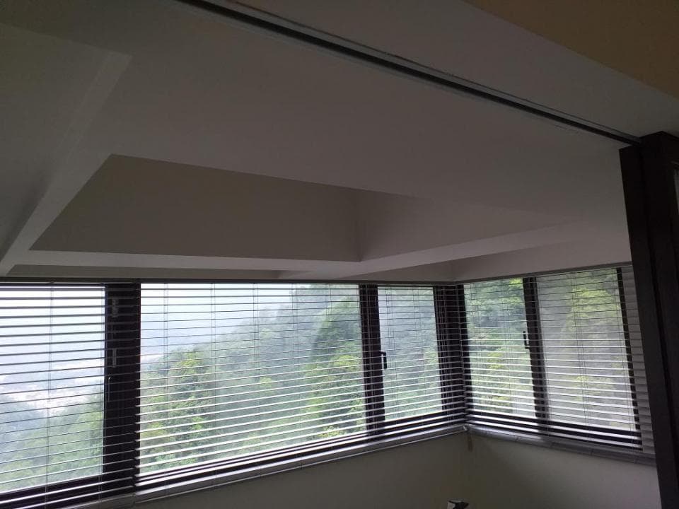 1) 照片顯示一個房間的窗戶,窗戶上裝有百葉窗,窗外是綠色樹木