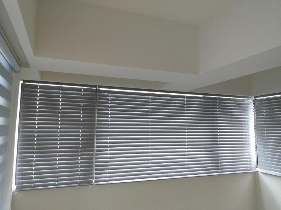 1) 照片顯示一間房間裡有三個灰色的百葉窗,窗戶從牆上延伸出來,窗戶看起來是新裝的