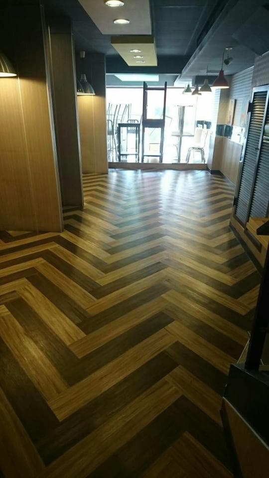 這張照片是木紋地板,地板上有深淺兩種木色,拼成魚骨狀。