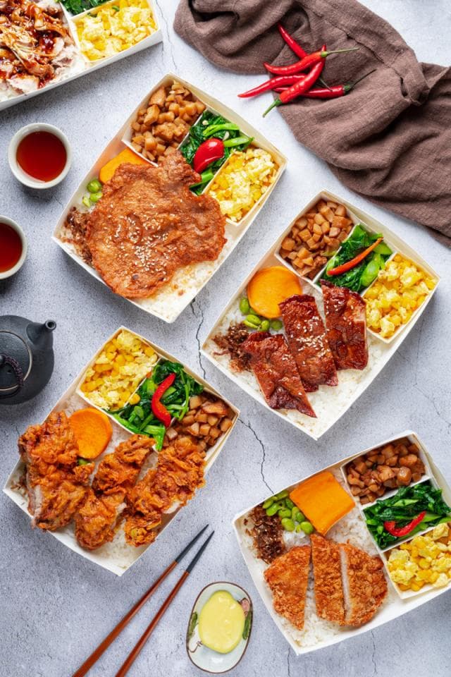 這張「便當」的照片是四個不同口味的便當,每一個便當都包含了米飯、肉類、蔬菜和配菜。